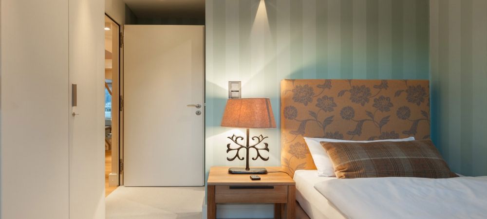 camera da letto con letto, lampada e porta