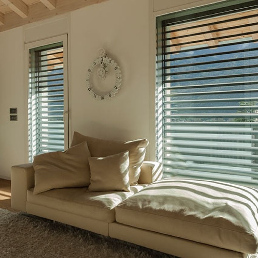 sala con divano e finestre con frangisole abbassati